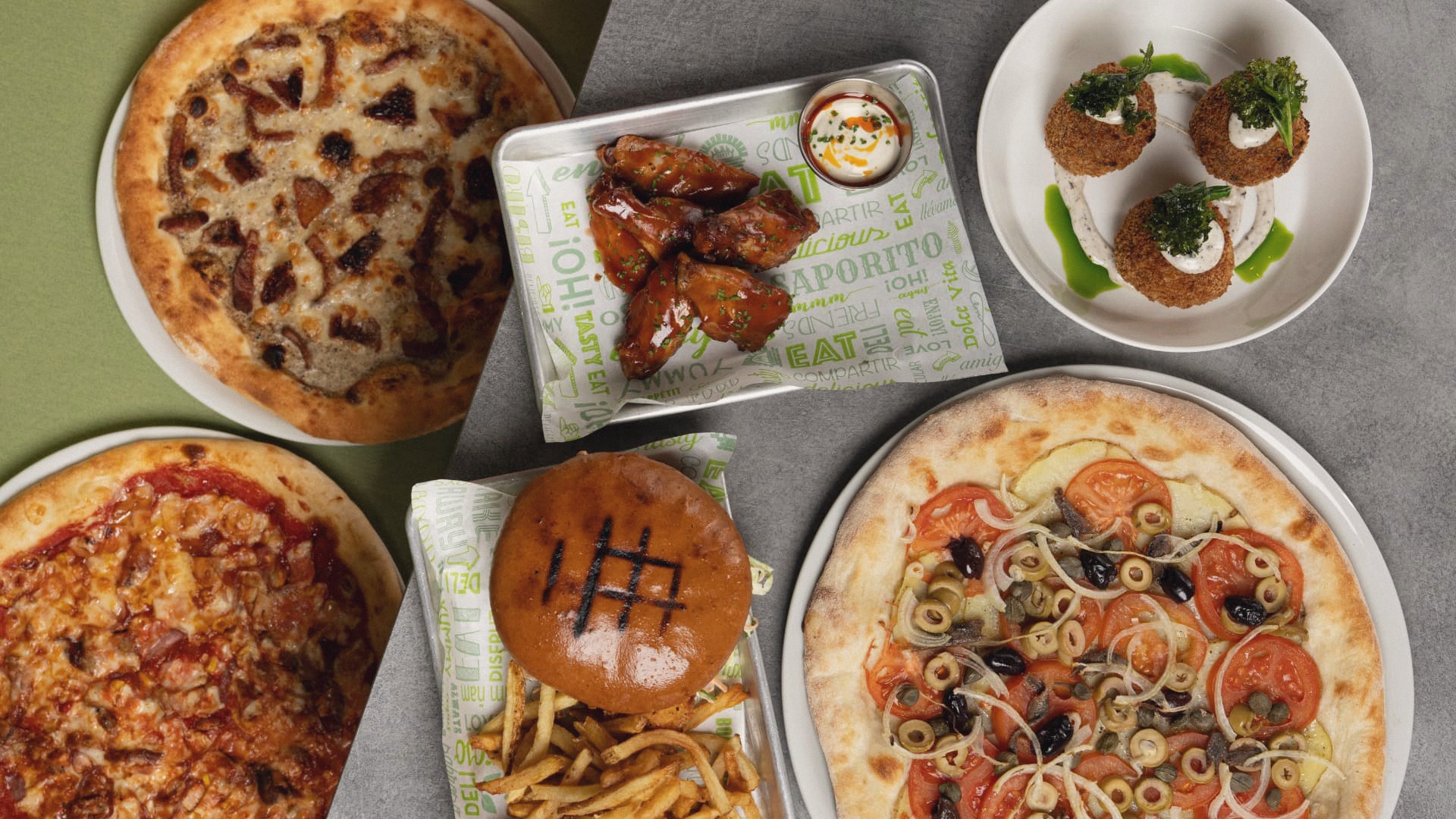 A shared table of pizzas, wings, croquettes and a Fumi burger