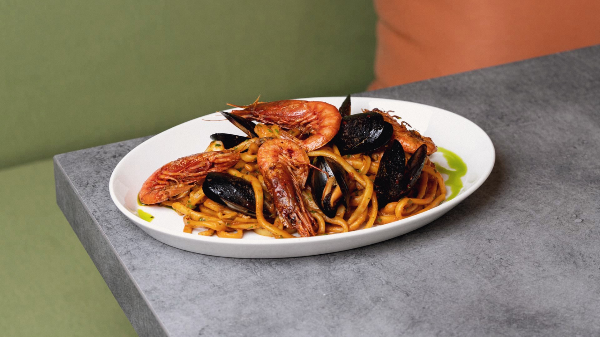 Seafood linguine with prawns and mussels on a white oval plate
